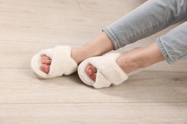 Yumuşak terlikli bir kadın. Evinde, ahşap zeminde. Kapalı.