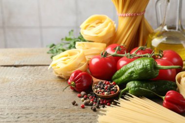 Farklı türde makarna ve malzemeler ahşap masada, yakın plan. Metin için boşluk