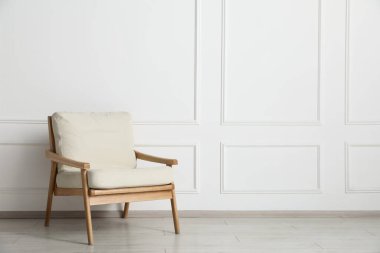 Beyaz duvarın yanındaki rahat koltuk, metin için boşluk