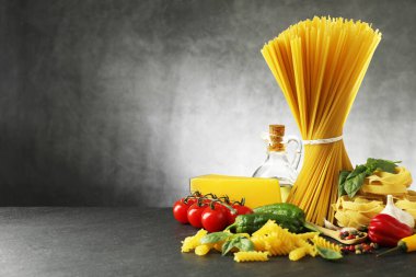 Siyah masa üzerinde değişik makarna ve malzemeler, metin için yer