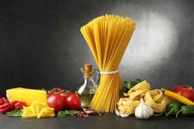 Siyah masada değişik makarna ve malzemeler var.