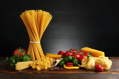 Tahta masadaki farklı makarna ve malzemeler.