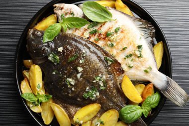 Siyah masada otlu ve patatesli kızarmış balık, harika bir manzara. Ev yapımı deniz ürünleri yemeği.