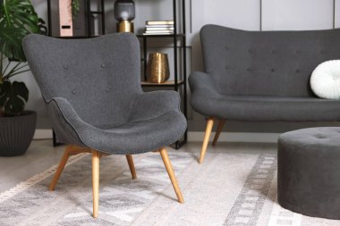 Şık gri koltuk, kanepe ve içeride puf. İç tasarım