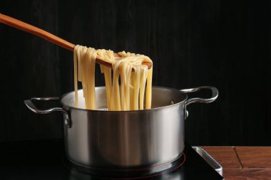 Haşlanmış tagliatelle makarnasını elektrikli ocaktan kaşıkla alıp, yakın plan çekiyoruz.