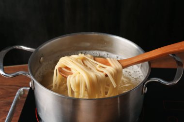 Haşlanmış tagliatelle makarnasını elektrikli ocaktan kaşıkla alıp, yakın plan çekiyoruz.