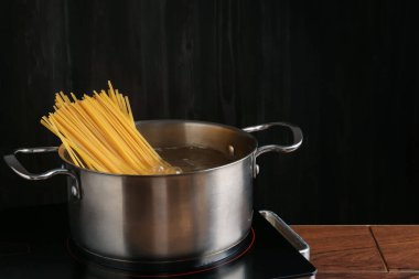 Tencerede taze tagliatelle makarna ve elektrikli fırında su.