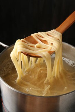 Haşlanmış tagliatelle makarnasını elektrikli ocaktan kaşıkla alıp, yakın plan çekiyoruz.