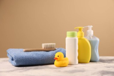 Bebek aksesuarları ve banyo ürünleri bej arka plana karşı gri desenli masa üzerinde