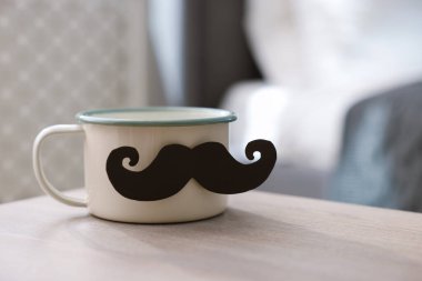 Babalar Günün kutlu olsun. Evdeki tahta masada bıyıklı fincan, yakın plan. Metin için boşluk