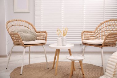 Oturma odasında rahat koltuklar ve masalar. İç tasarım