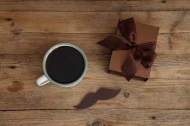 Babalar Günün kutlu olsun. Bıyıklı kupa ve hediye ahşap masada, düz yatıyordu.