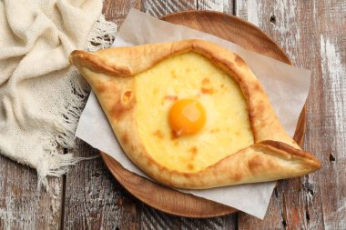 Tahta masadaki peynirli ve yumurtalı leziz khachapuri.