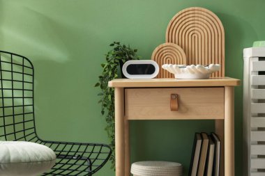 İçerideki yeşil duvarın yanında şık dekorlu ahşap masa, yakın plan.