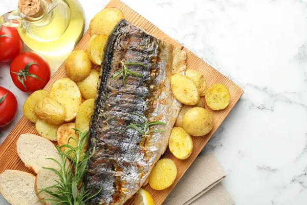 Ev yapımı deniz ürünleri yemeği. Lezzetli kavrulmuş uskumru, baharatlar ve sebzeler beyaz mermer masada, düz yerde. Metin için boşluk