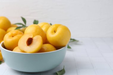 Beyaz fayanslı masada olgun sarı kiraz erikleri, yakın plan. Metin için boşluk