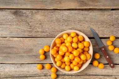 Olgun sarı kiraz erikleri ve tahta masa üzerinde bıçak, düz yatıyordu. Metin için boşluk