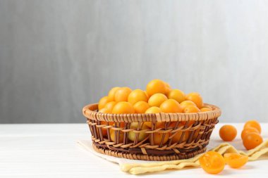 Beyaz ahşap masada olgun sarı kiraz erikleri. Metin için boşluk