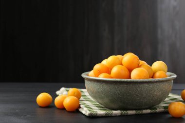 Siyah ahşap masada olgun sarı kiraz erikleri. Metin için boşluk