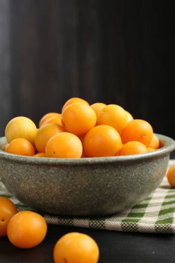 Siyah ahşap masada olgun sarı kiraz erikleri. Metin için boşluk