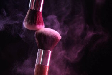 Renkli göz gölgeli makyaj fırçaları siyah arka planda neon ışıkları, yakın plan. Metin için boşluk