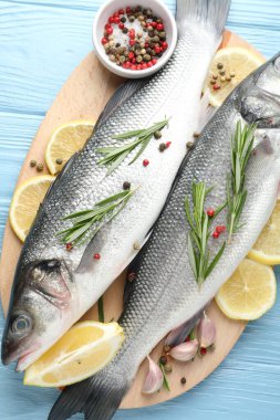 Mavi ahşap masadaki baharatlı taze çiğ deniz kabuğu. Balık ve deniz ürünleri lezzetleri