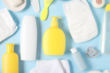 Açık mavi zemin üzerinde bebek aksesuarları ve kozmetik ürünleri, düz uzanma