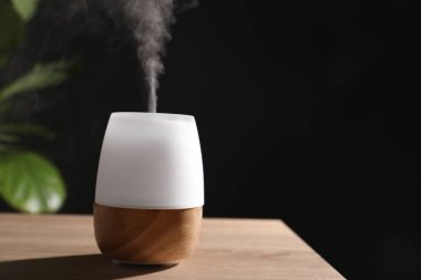 Ahşap masa üzerinde modern aroma lambası. Metin için boşluk