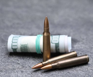 Mermiler ve dolarlar gri masaya, yakın plan.