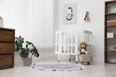 Bebek odasında rahat bir beşik ve oyuncak ayı var. İç tasarım