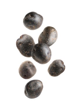 Beyaz zemine düşen taze mor patatesler.