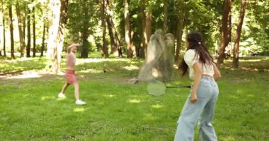 Parkta badminton oynayan sevimli küçük kızlar, kamera hareket ediyor.