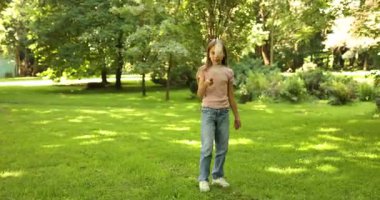 Parkta badminton oynayan gülümseyen küçük kız