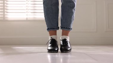 Tap ayakkabılı genç kız içeride dans ediyor, yakın plan.