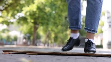 Step ayakkabılı genç kız dışarıda dans ediyor, yakın plan. Kamera sağa hareket ediyor