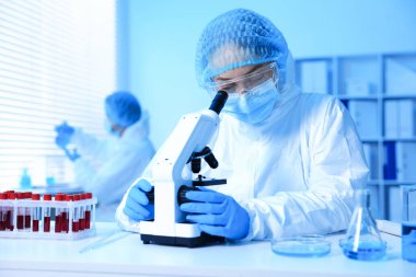 Tıbbi analiz. Laboratuvarda mikroskopla çalışan bilim adamı, seçici odaklanma