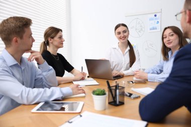 İş koçu ofisteki bir grup insana sunum yapıyor.