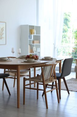 Yemek odasında güzel bir masa, sandalye ve dekor var. İç tasarım