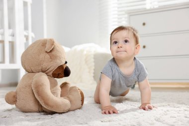 Odasında oyuncak ayı olan şirin bir bebek.