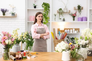Dükkandaki ahşap masada çalışan profesyonel bir çiçekçi.
