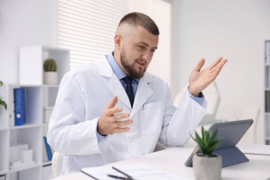 Doktor içeride tabletle çevrimiçi danışmanlık yapıyor.