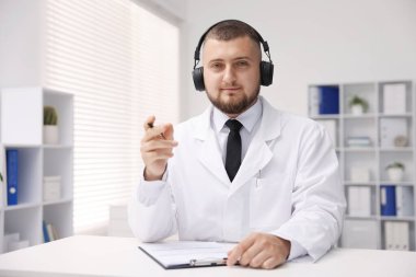 Kulaklıklı doktor içeride online danışmanlık yapıyor.