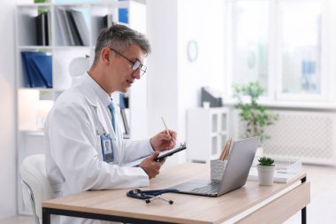 Teletıp. Doktor içeride bilgisayarla hastayla görüntülü konuşma yaparken not alıyor.