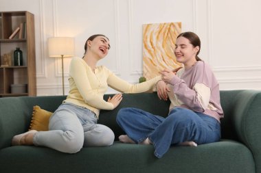 Arkadaşlar kanepede gülüyor. Pozitif duygu