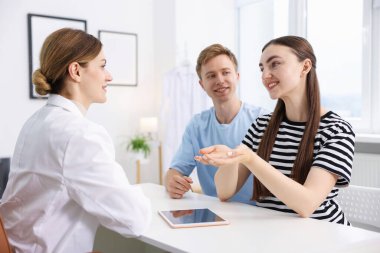 Tüp bebek (tüp bebek). Mutlu çiftin üreme kliniğinde doktorla randevusu var.