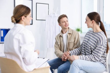 Tüp bebek (tüp bebek). Mutlu çiftin üreme kliniğinde doktorla randevusu var.