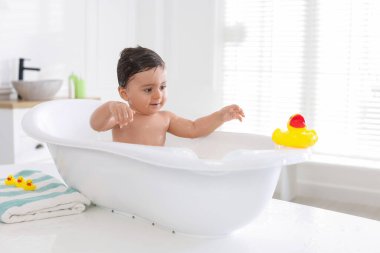 Evde küvette banyo yapan şirin bir bebek.