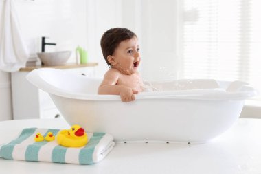 Evde küvette banyo yapan şirin bir bebek.