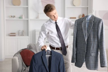 Hazırlanıyor. Genç adam evde kıyafet seçiyor.