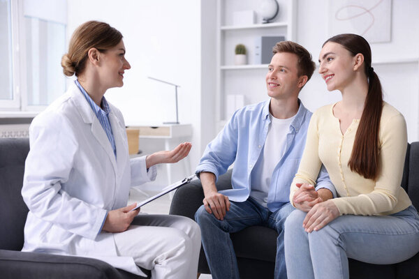 Оплодотворение in vitro (ЭКО). Счастливая пара, встречающаяся с врачом в репродуктивной клинике